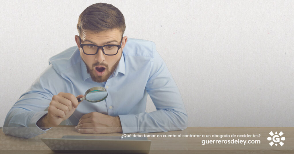 Hombre observa laptop con lupa